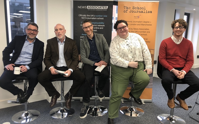 A panel of five journalists all sitting on bar stools in a row.