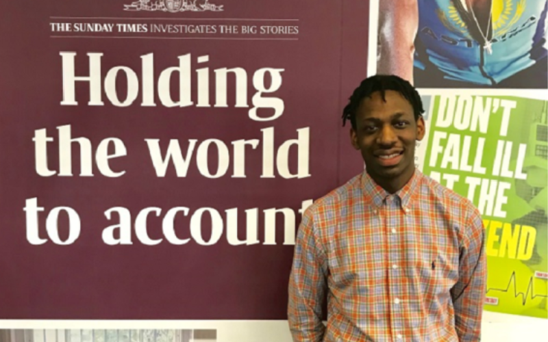 NCTJ-accredited journalist Shingi is standing in front of a Sunday Times banner which reads "Holding the world to account"
