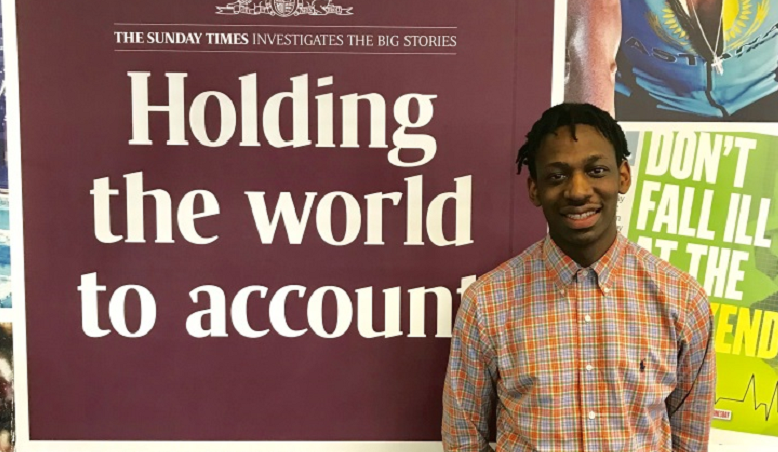 NCTJ-accredited journalist Shingi is standing in front of a Sunday Times banner which reads "Holding the world to account"