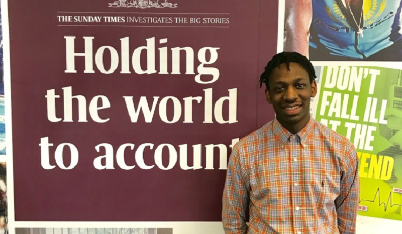 Shingi Mararike standing in front of a Sunday Times banner