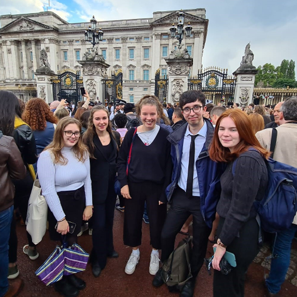 News Associates trainees gather reaction of Queen Elizabeth II's death at Buckingham Palace. From left to right you can see Heather Nicholls, Jasmine Laws, Olivia Christie, Max Kendix and Rachel Duffy standing among a crowd of people in front of the palace.