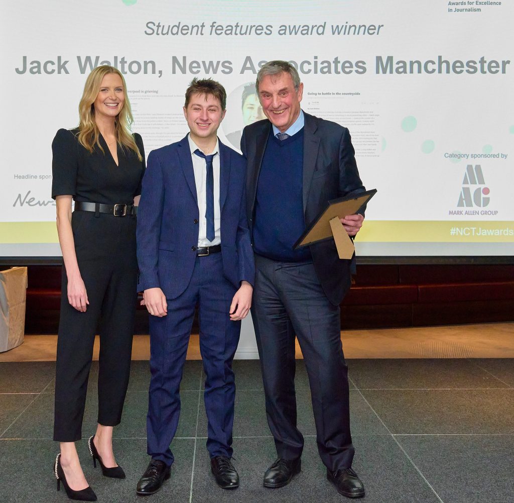 News Associates graduate Jack Walton (centre) collecting his award from Sky Sports News presenter Jo Wilson (left) and Mark Allen Group founder and executive chairman Mark Allen (right). They are all standing and smiling for the camera. They are all smartly dressed. Jack is holding the glass award. 