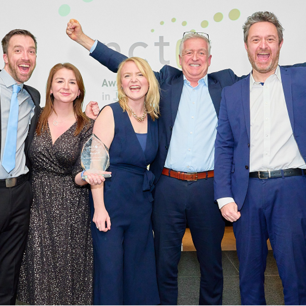 L-R: News Associates staff Graham Moody, Lucy Dyer, Rachel Bull, Graham Dudman and James all jumping for joy posing for the camera as they celebrate winning innovation of the year at the NCTJ Awards for Excellence!