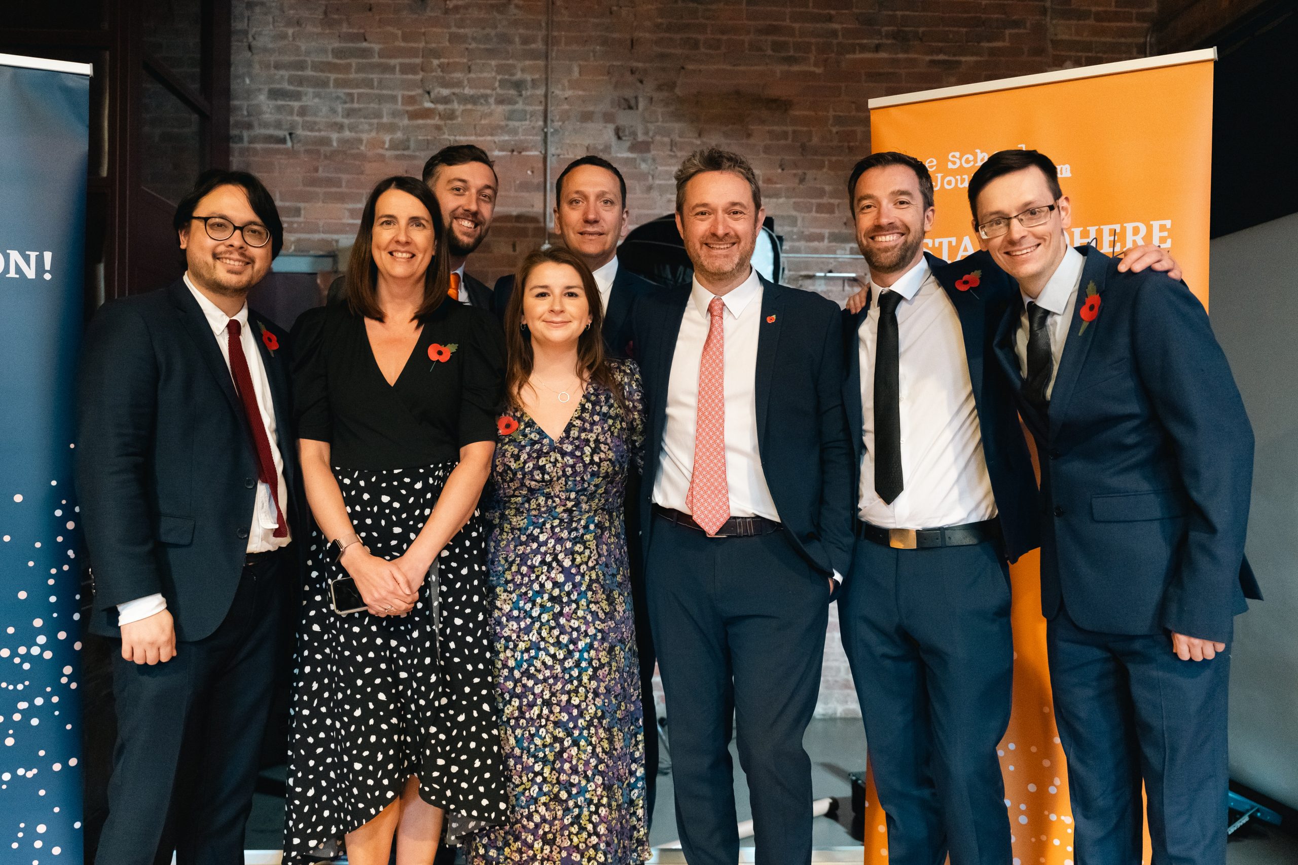 A group photo of the News Associates training team, including Paul, Alice, Kieran, Phil, Lucy, James, Graham and Tom. The photo was taken at graduation 2023 so everyone is dressed up and looking happy. 