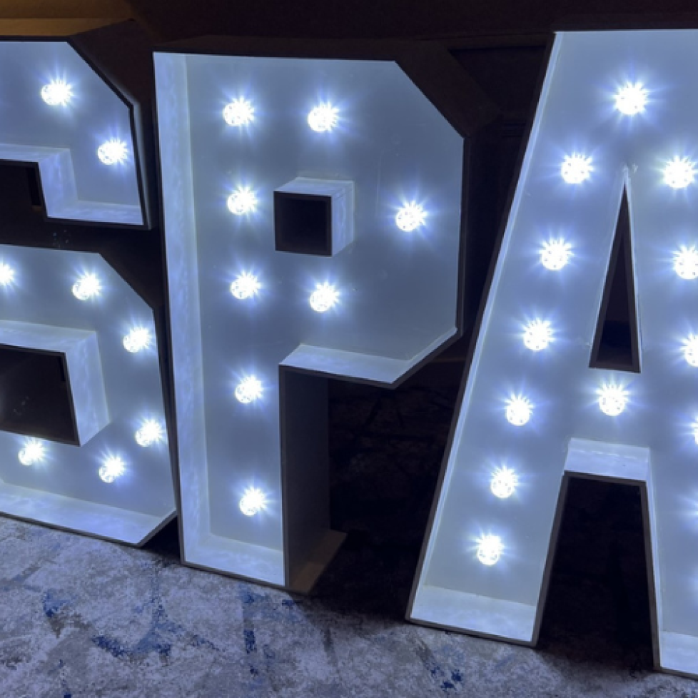 A photo of light up letters S, P and A which stand for Student Publication Association.