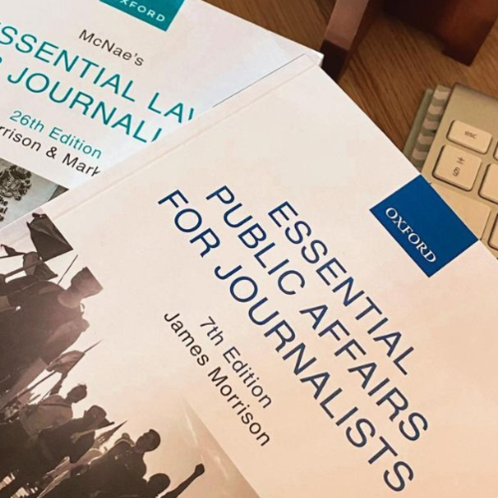 A Public Affairs and Media Law textbook on a desk next to a keyboard.